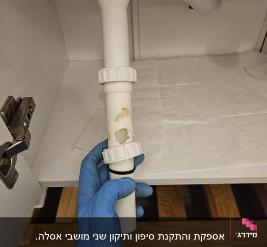 יד בכפפה כחולה מחזיקה צינור לבן עם חור